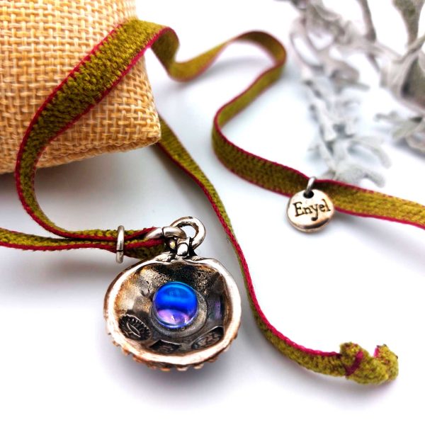 detalle del collar con concha y perla azul de cristal sobre cojin