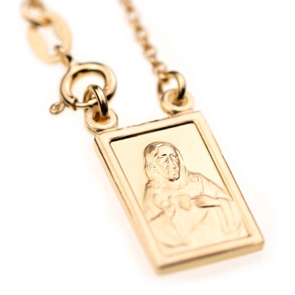 escapulario dorado con cadena y mosqueton y medalla de forma rectangular con imagen de jesucristo en busto señalando su corazon en llamas